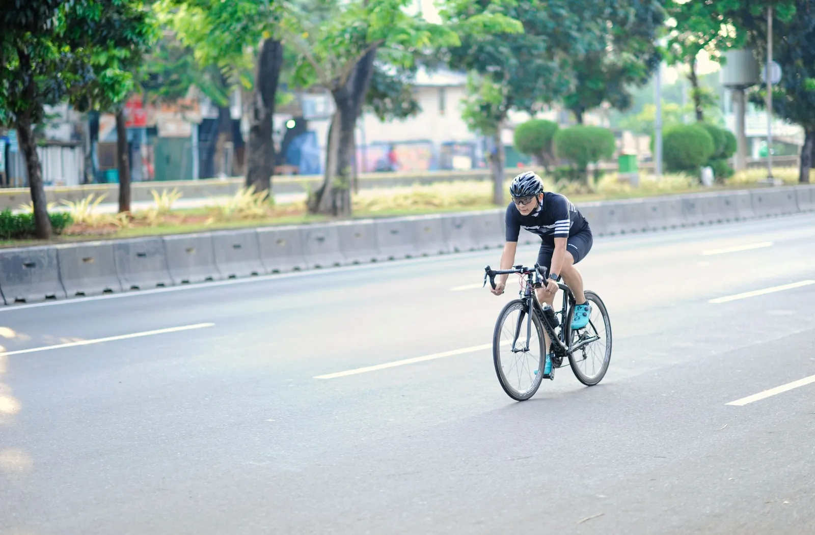 Pesepeda melintas di jalan rindang Jakarta