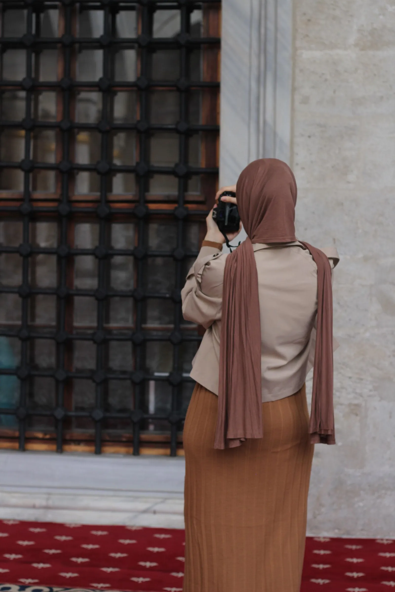 Fotografer perempuan berhijab mendokumentasikan arsitektur